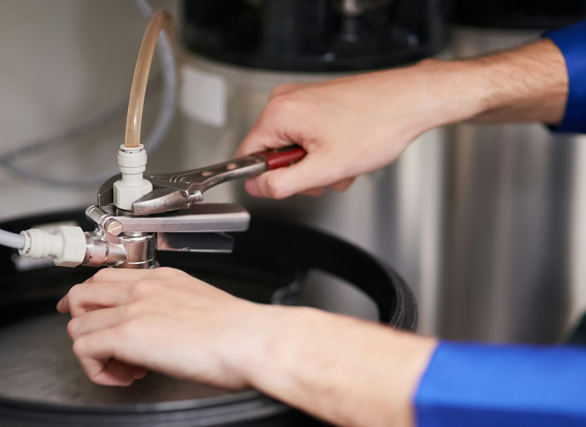 Cropped shot of a handyman repairing a pipe on a water heater Cropped shot of a handyman repairing a pipe on a water heater